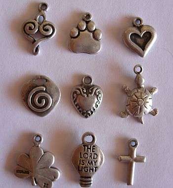A LITTLE LOT OF 9 STERLING SILVER CHARMS - ONE BID FOR ALL