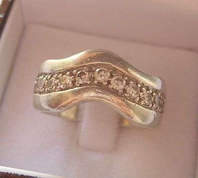 A STERLING SILVER WIDE BAND RING SET WITH FACETED CZ STONES