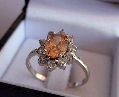A MARVELOUS STERLING SILVER RING SET WITH A BRIGHT FACETED ORANGE STONE AND FACETED CZ STONES
