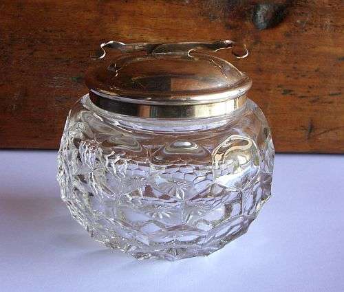 AN EARLY 20TH CENTURY THICK GLASS SUGAR BOWL WITH A BUILT IN SUGAR NIP