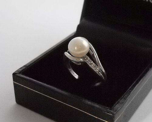 A SOLID STERLING SILVER RING SET WITH FACETED CZ STONES AND A MABE PEARL