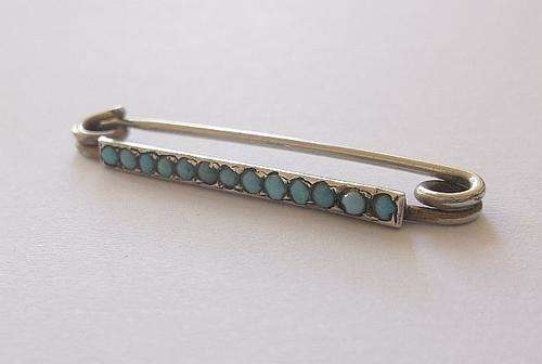 A CHARMING ART DECO PERIOD SILVER BROOCH SET WITH TINY BLUE BALLS ....TURQUOISE ??