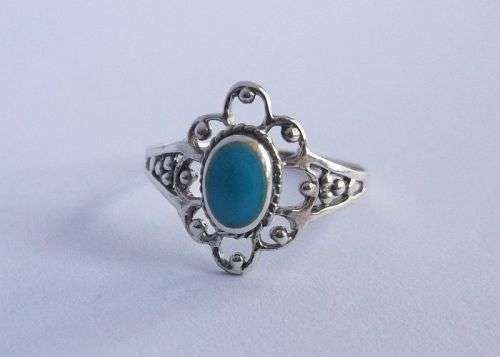 AN EYE CATCHING STERLING SILVER RING WITH FLORAL LOOK AND TURQUOISE COLORED INSET....KYK HIER