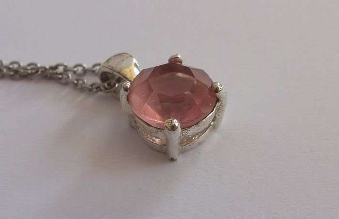 A STERLING SILVER NECKLACE WITH A FACETED PINK STONE SET STERLING SILVER PENDANT