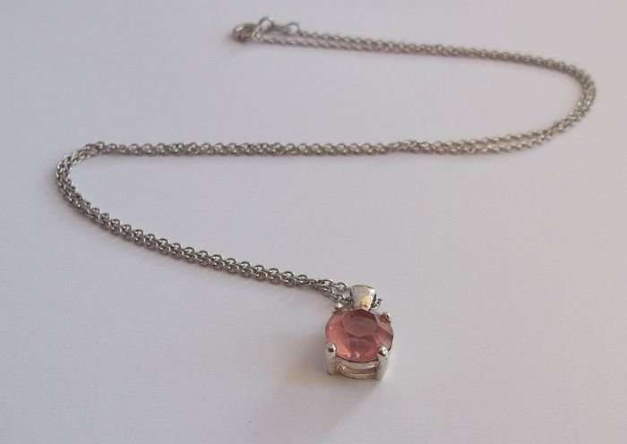 A STERLING SILVER NECKLACE WITH A FACETED PINK STONE SET STERLING SILVER PENDANT