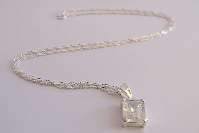 A STERLING SILVER NECKLACE PLUS A STERLING SILVER PENDANT SET WITH A CLEAR FACETED STONE