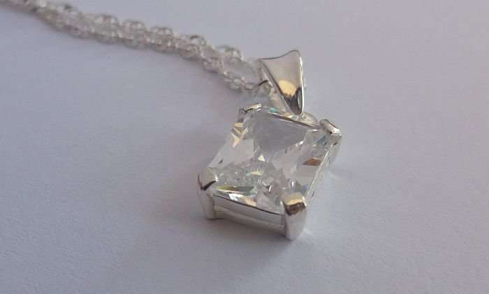 A STERLING SILVER NECKLACE PLUS A STERLING SILVER PENDANT SET WITH A CLEAR FACETED STONE