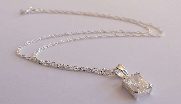 A STERLING SILVER NECKLACE PLUS A STERLING SILVER PENDANT SET WITH A CLEAR FACETED STONE