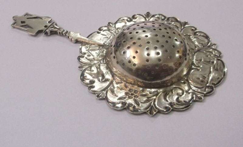 An old solid Dutch silver tea strainer with beautiful detail and applicable stamps