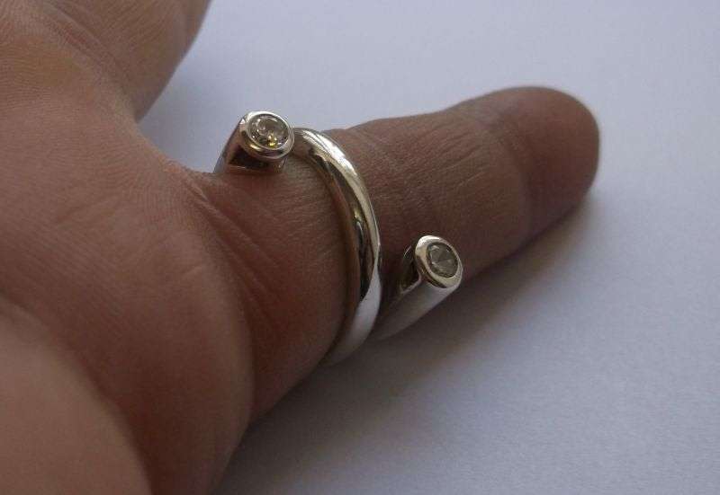 An Elegant and excellent Quality solid Sterling Silver ring ....with a TWIST ...and faceted Stones