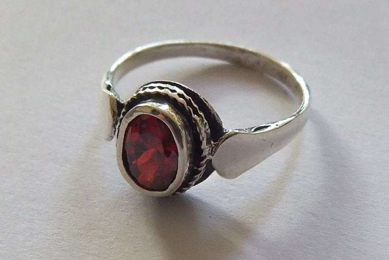 A Fancy Solid Sterling Silver ring set with a red faceted Cubic Zirconia !! No Combining Fees !!