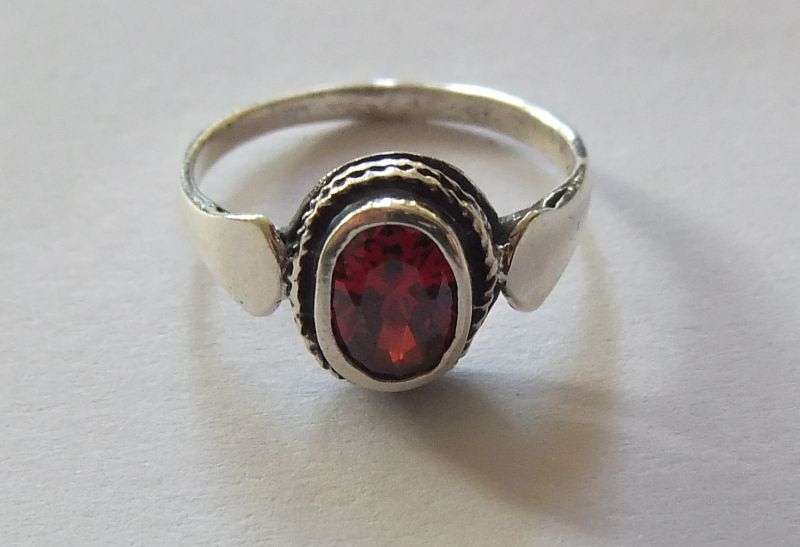 A Fancy Solid Sterling Silver ring set with a red faceted Cubic Zirconia !! No Combining Fees !!