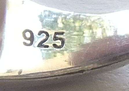 AN EXQUISITE SOLID STERLING SILVER RING SET WITH A FACETED BLUE STONE AND TINY CLEAR FACETED STONES