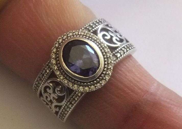AN EXQUISITE SOLID STERLING SILVER RING SET WITH A FACETED BLUE STONE AND TINY CLEAR FACETED STONES