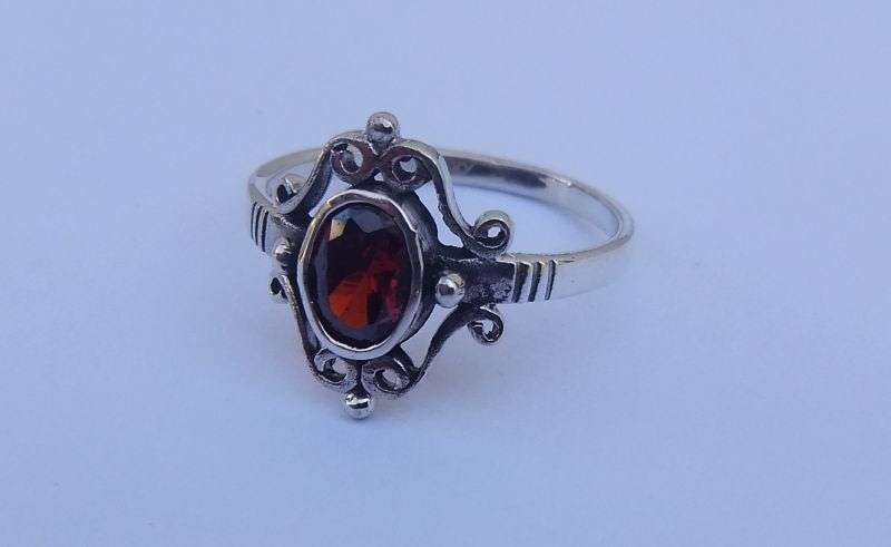A VERY STYLISH SOLID STERLING SILVER RING SET WITH AN EYE CATCHING FACETED RED STONE !! WOW !!