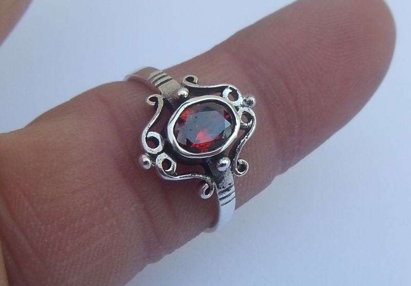 A VERY STYLISH SOLID STERLING SILVER RING SET WITH AN EYE CATCHING FACETED RED STONE !! WOW !!