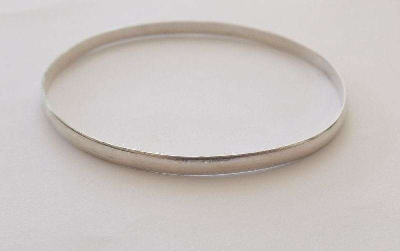 A SOLID STERLING SILVER BANGLE