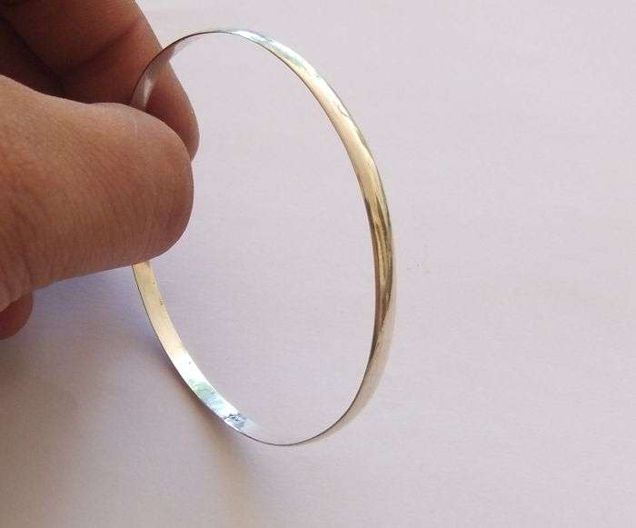 A SOLID STERLING SILVER BANGLE