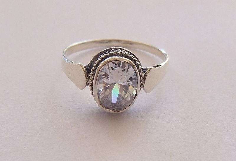 AN EYE CATCHING SOLID STERLING SILVER RING SET WITH A SPARKLY FACETED STONE !! NEVER WORN ...