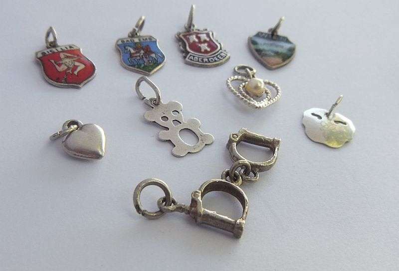 A LOT OF 9 VINTAGE SILVER AND STERLING SILVER CHARMS ...ENAMEL , TEDDY , CUFFS , HEART AND MORE !!