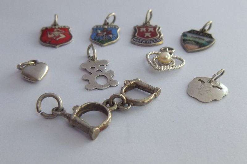 A LOT OF 9 VINTAGE SILVER AND STERLING SILVER CHARMS ...ENAMEL , TEDDY , CUFFS , HEART AND MORE !!