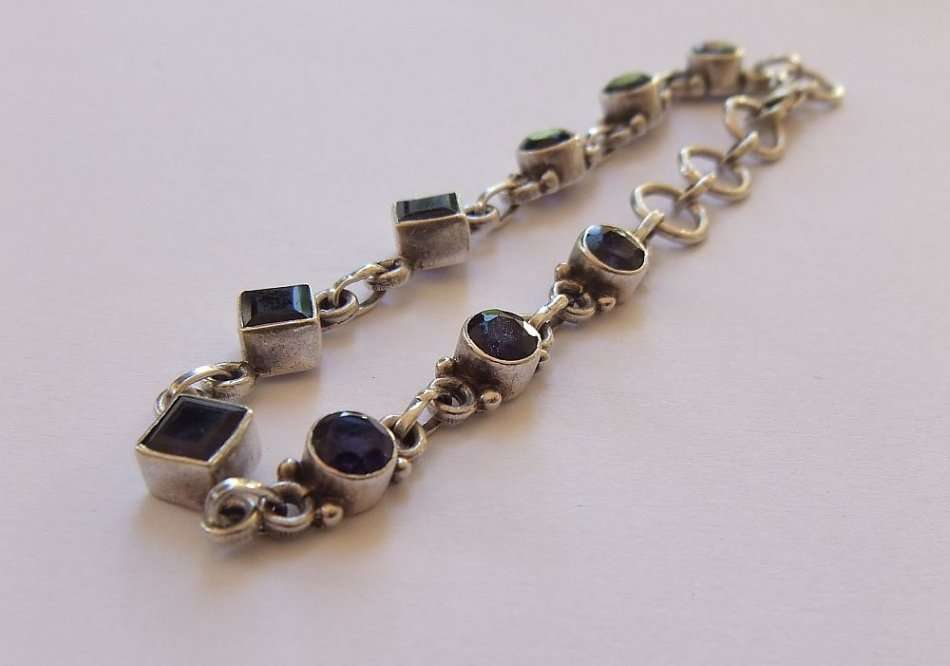 AN EYE CATCHING SOLID STERLING SILVER BRACELET SET WITH FACETED BLUEISH PURPLISH STONES !! QUALITY !