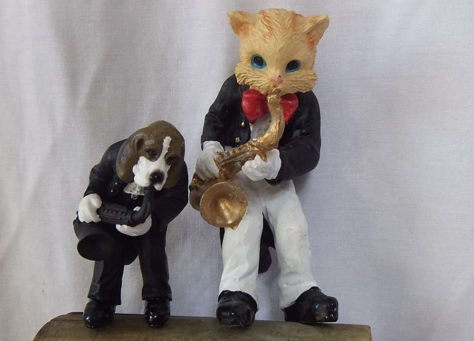 AN UNLIKELY COUPLE !! TWO DETAILED RESIN COMPOSITE FIGURES OF MUSICIANS PLAYING THE SAXOPHONE !!