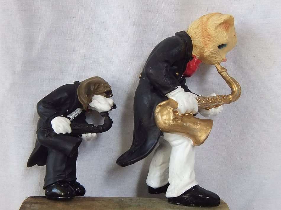 AN UNLIKELY COUPLE !! TWO DETAILED RESIN COMPOSITE FIGURES OF MUSICIANS PLAYING THE SAXOPHONE !!