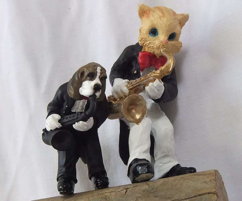 AN UNLIKELY COUPLE !! TWO DETAILED RESIN COMPOSITE FIGURES OF MUSICIANS PLAYING THE SAXOPHONE !!