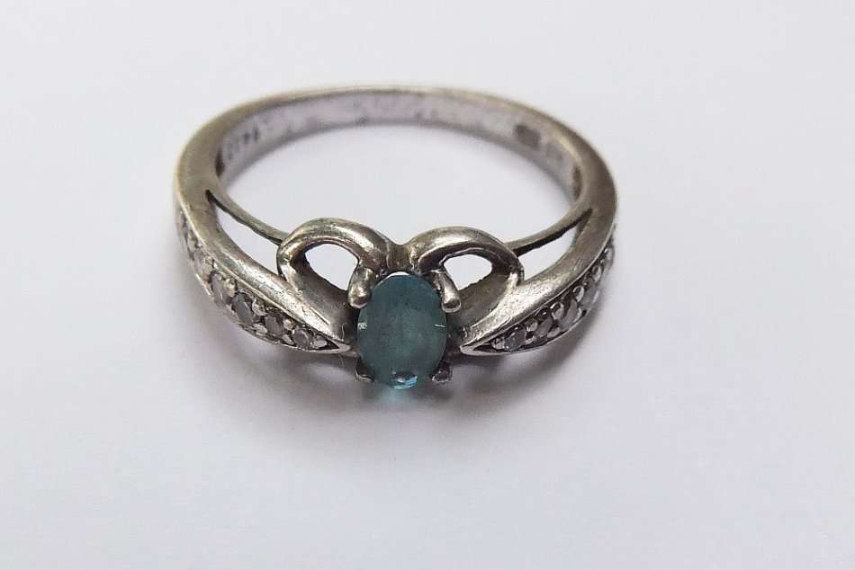 A SOLID STERLING SILVER DESIGNER STAMPED RING WITH FACETED PALE BLUE STONE - STAMPED AND TESTED