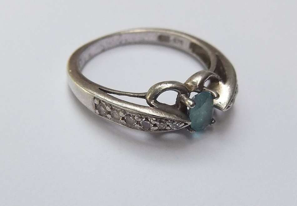 A SOLID STERLING SILVER DESIGNER STAMPED RING WITH FACETED PALE BLUE STONE - STAMPED AND TESTED