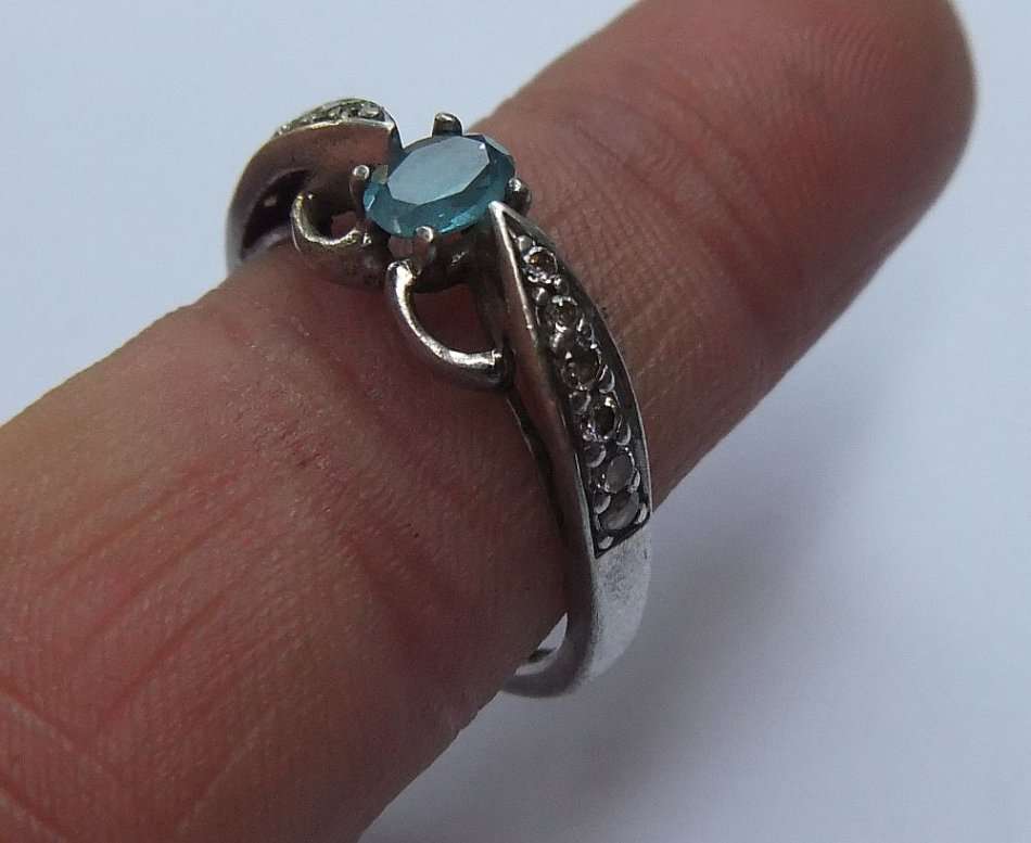 A SOLID STERLING SILVER DESIGNER STAMPED RING WITH FACETED PALE BLUE STONE - STAMPED AND TESTED