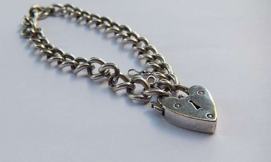 A VINTAGE SOLID STERLING SILVER STARTER CHARM BRACELET WITH HEART CLASP - STAMPED AND TESTED