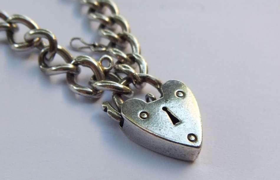 A VINTAGE SOLID STERLING SILVER STARTER CHARM BRACELET WITH HEART CLASP - STAMPED AND TESTED