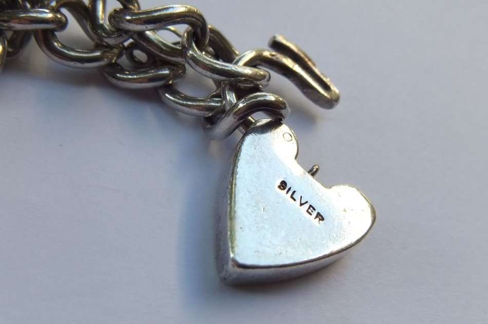 A VINTAGE SOLID STERLING SILVER STARTER CHARM BRACELET WITH HEART CLASP - STAMPED AND TESTED