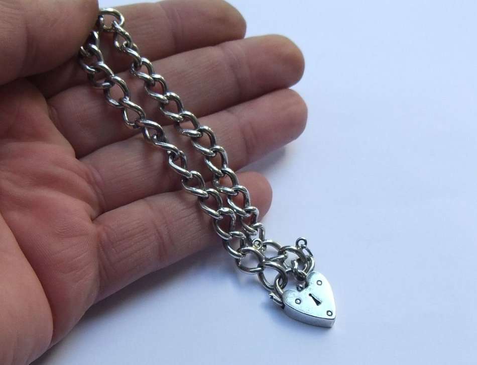 A VINTAGE SOLID STERLING SILVER STARTER CHARM BRACELET WITH HEART CLASP - STAMPED AND TESTED