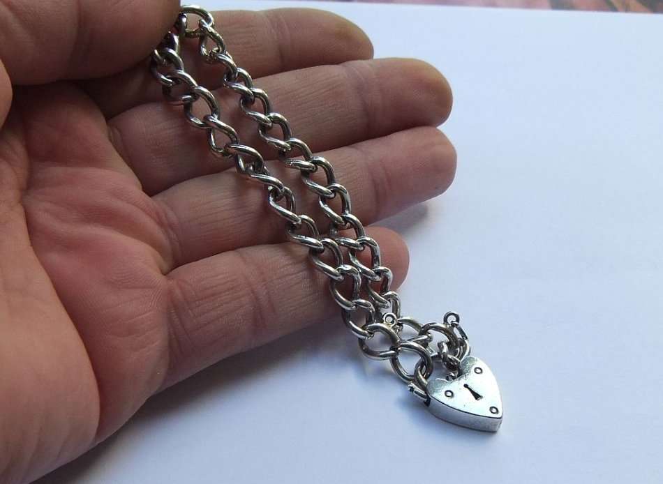 A VINTAGE SOLID STERLING SILVER STARTER CHARM BRACELET WITH HEART CLASP - STAMPED AND TESTED