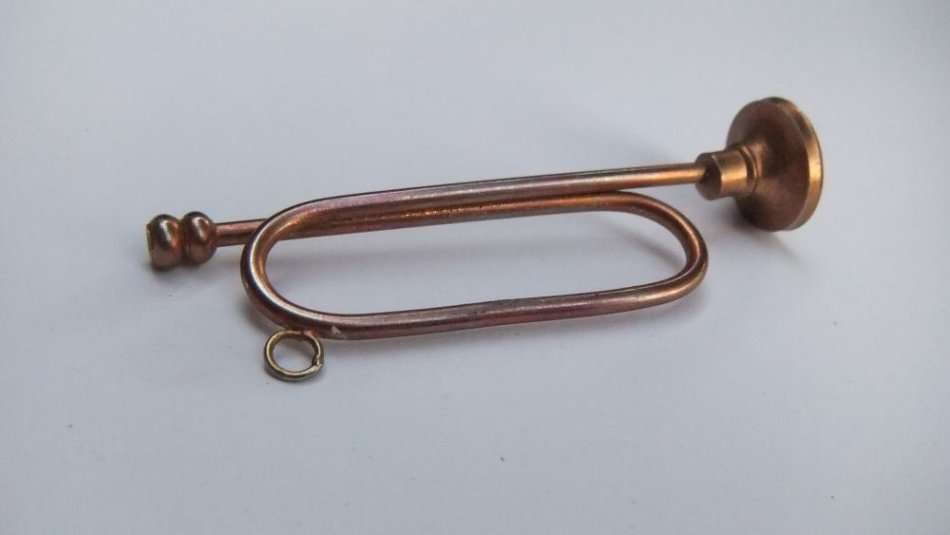 A MINIATURE METAL MODEL OF A BUGLE