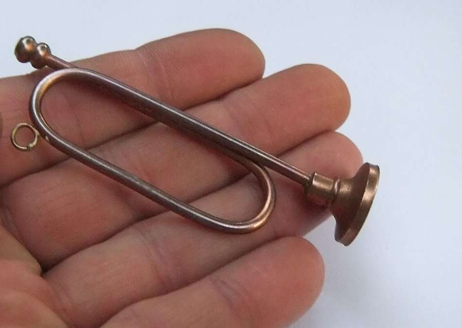 A MINIATURE METAL MODEL OF A BUGLE