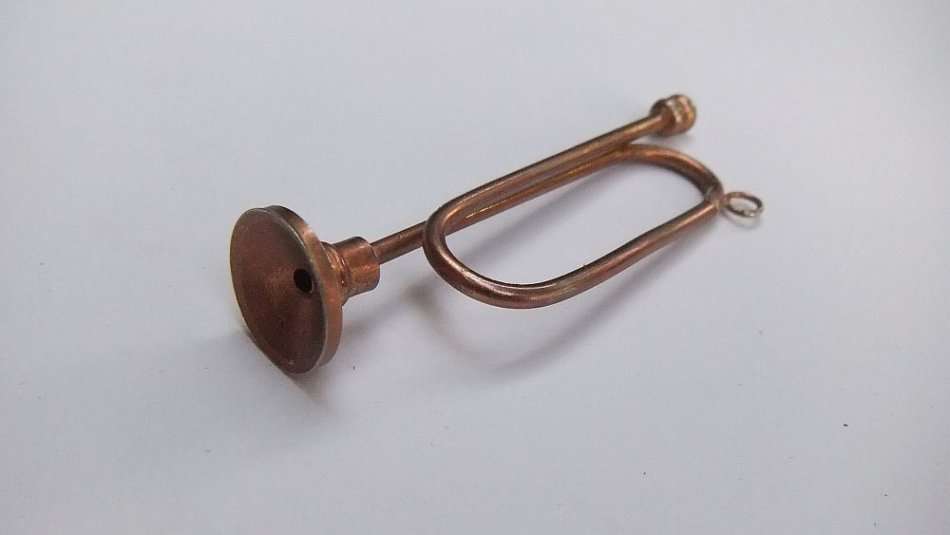A MINIATURE METAL MODEL OF A BUGLE