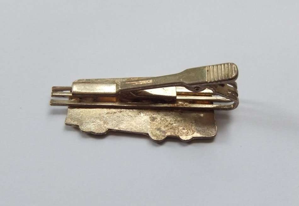 A VINTAGE TIE CLIP WITH TOUR BUS MOTIF