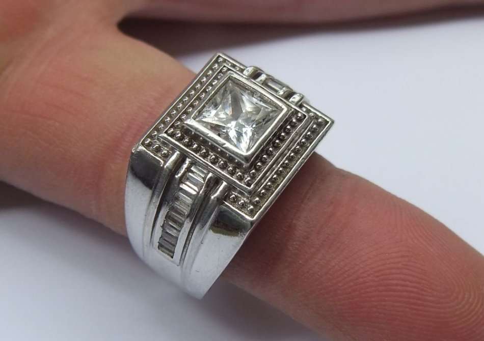 A SUPERIOR QUALITY SOLID STERLING SILVER RING SET WITH FACETED BAGUETTE CUT STONES AND A SQUARE CZ