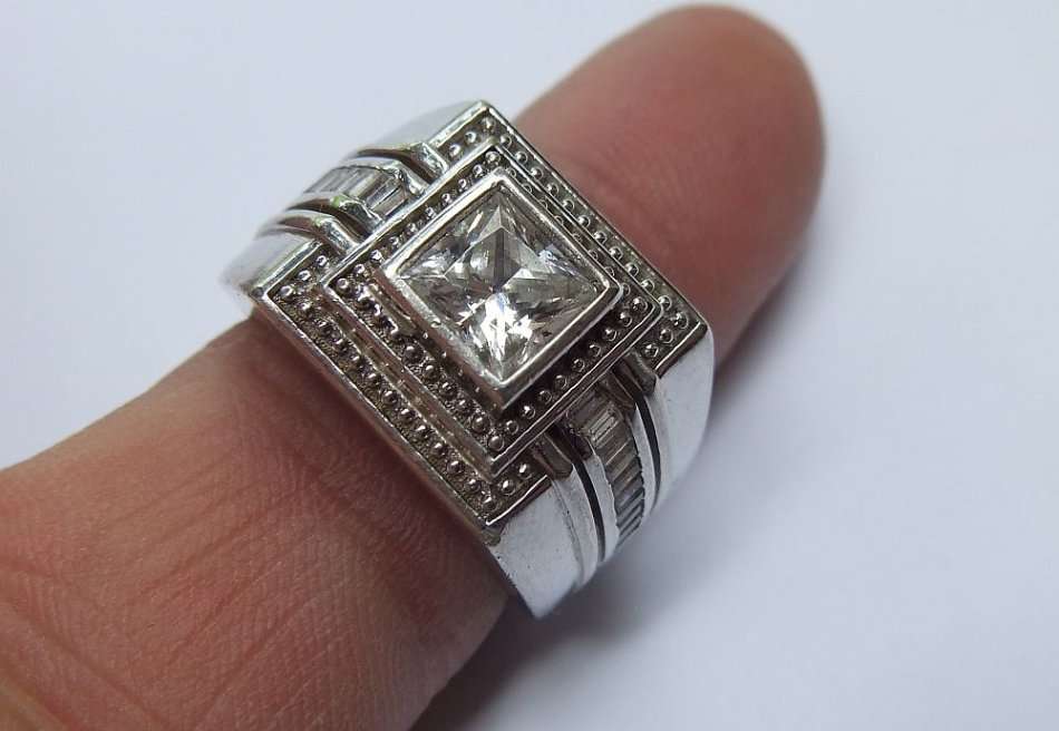 A SUPERIOR QUALITY SOLID STERLING SILVER RING SET WITH FACETED BAGUETTE CUT STONES AND A SQUARE CZ