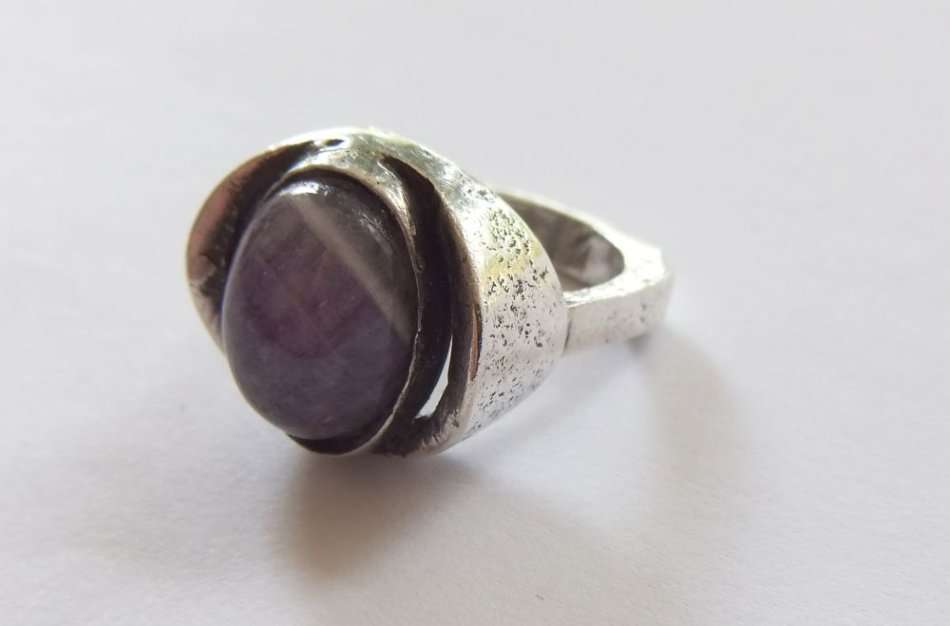 A RARE VINTAGE SOLID STERLING SILVER RING SET WITH A CABOCHON AMETHYST BY DANISH DESIGNER N.E FROM