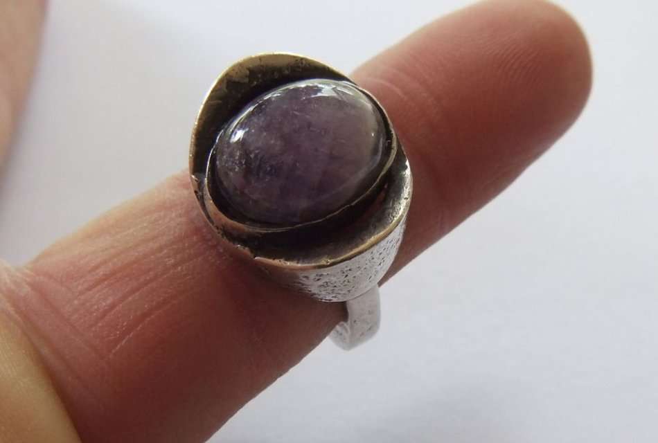 A RARE VINTAGE SOLID STERLING SILVER RING SET WITH A CABOCHON AMETHYST BY DANISH DESIGNER N.E FROM