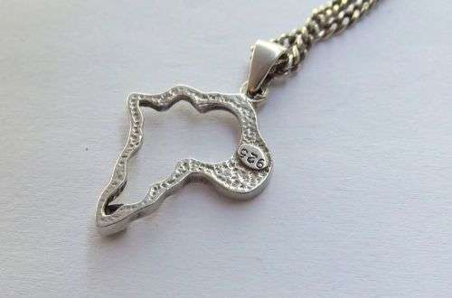 A COOL SOLID STERLING SILVER AFRICA PENDANT SET WITH A FACETED STONE PLUS A STERLING SILVER NECKLACE