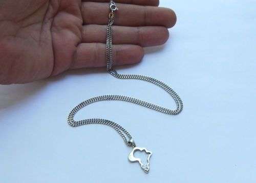A COOL SOLID STERLING SILVER AFRICA PENDANT SET WITH A FACETED STONE PLUS A STERLING SILVER NECKLACE