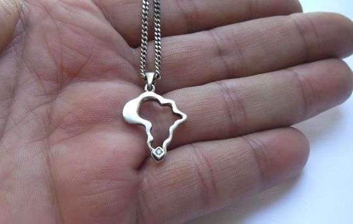 A COOL SOLID STERLING SILVER AFRICA PENDANT SET WITH A FACETED STONE PLUS A STERLING SILVER NECKLACE