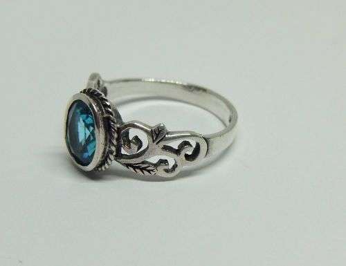 WOW ! A STUNNING SOLID STERLING SILVER RING SET WITH A FACETED LIGHT BLUE STONE !! LOTS OF CURVES !!