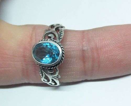 WOW ! A STUNNING SOLID STERLING SILVER RING SET WITH A FACETED LIGHT BLUE STONE !! LOTS OF CURVES !!